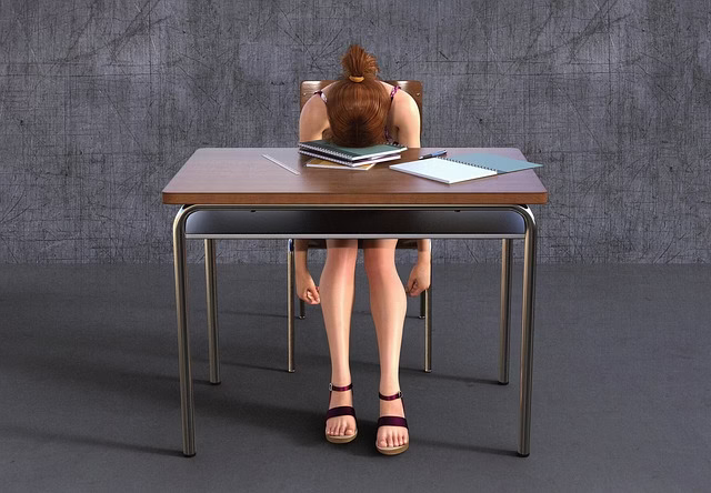 机で伏せる女子